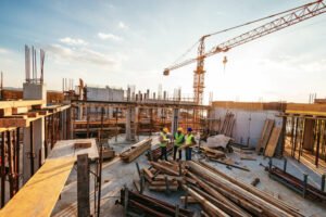 Construction workers in hard hats and safety vests actively working on a commercial construction site, ensuring compliance with building regulations and permits.