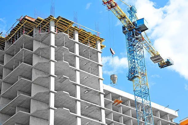 Construction crane atop a building, indicating ongoing commercial construction work in an urban setting.